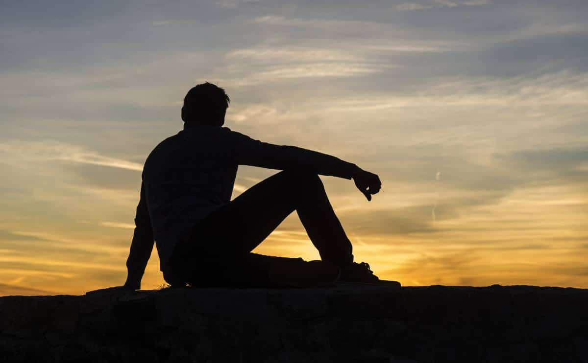 Do You Ever Ponder Our Purpose? A person silhouette sitting looking at sunset thinking.