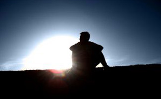 Man sitting on hill alone