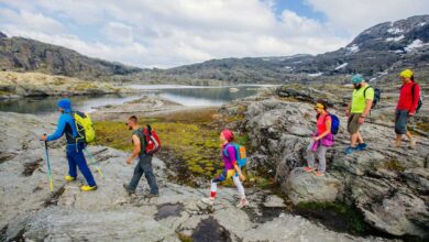 six hikers walking along lake in mountainous norway jpg