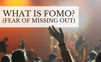 Person waving hand in crowd: What is FOMO (Fear of Missing Out)?